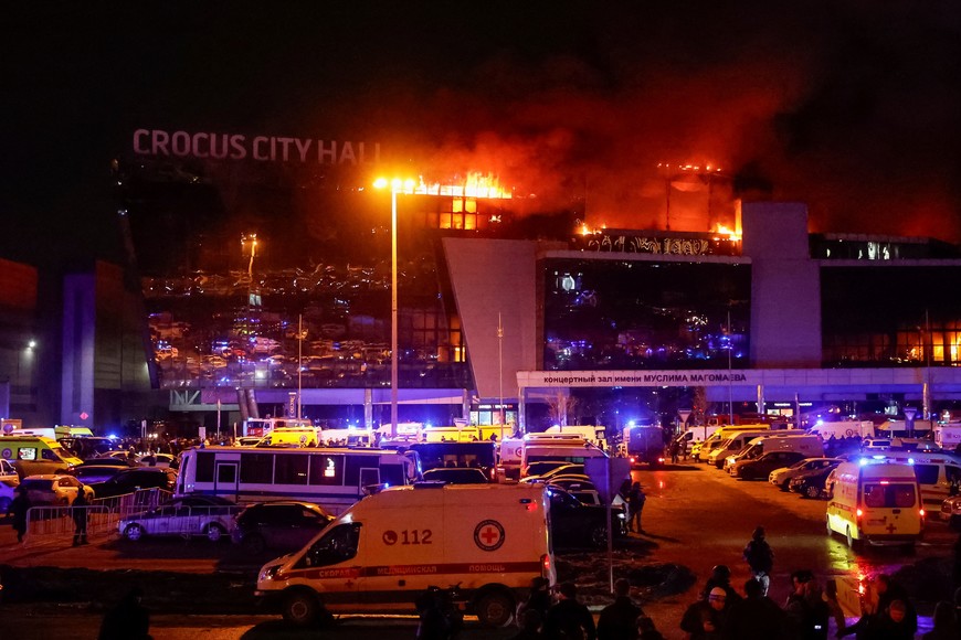 Ambulances and vehicles of Russian emergency services are parked at the burning Crocus City Hall concert venue following a shooting incident, outside Moscow, Russia, March 22, 2024. REUTERS/Yulia Morozova