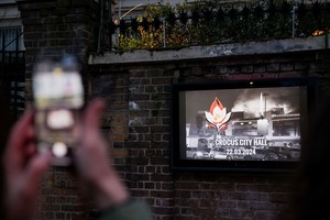 A tribute to the victims of a shooting at the Crocus City Hall concert venue in the Moscow Region is displayed on a screen, outside the Russian embassy in London, Britain March 23, 2024. REUTERS/Hollie Adams