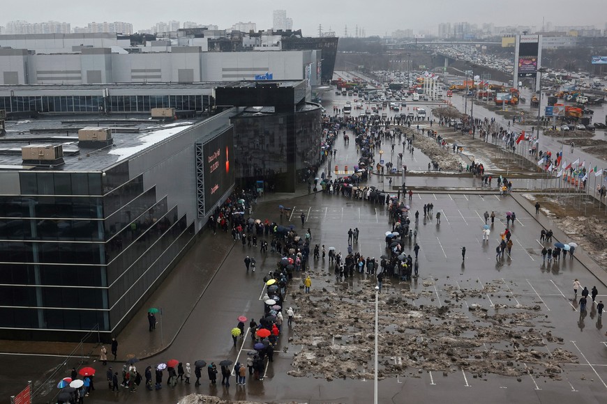 People line up to lay flowers at a makeshift memorial to the victims of a shooting attack set up outside the Crocus City Hall concert venue in the Moscow Region, Russia, March 24, 2024. REUTERS/Maxim Shemetov