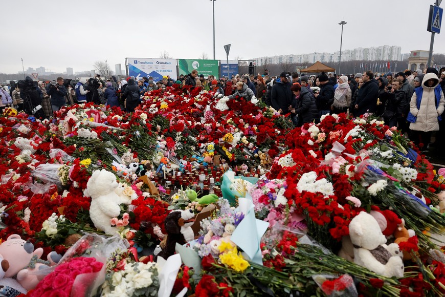 People lay flowers at a makeshift memorial to the victims of a shooting attack set up outside the Crocus City Hall concert venue in the Moscow Region, Russia, March 24, 2024. REUTERS/Maxim Shemetov
