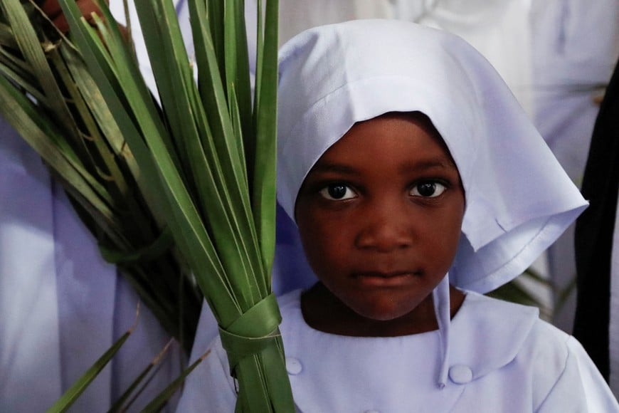 A child holds palm leaves as she attends a Palm Sunday mass at the St. Mary's, Legio Maria of African Church Mission in Makongeni district of Nairobi, Kenya March 24, 2024. REUTERS/Monicah Mwangi