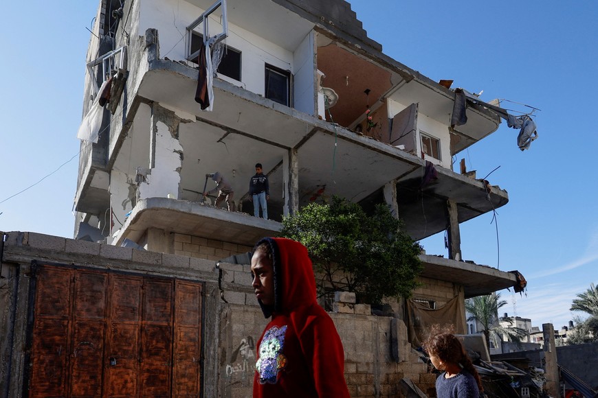 Palestinians walk near the site of an Israeli strike on a house, amid the ongoing conflict between Israel and the Palestinian Islamist group Hamas, in Rafah, in the southern Gaza Strip, March 25, 2024. REUTERS/Mohammed Salem