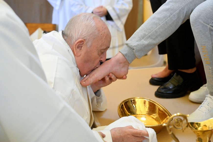 Pope Francis kisses the feet of an inmate of the female section of Rebibbia Prison during a Holy Thursday ritual, in Rome, Italy March 28, 2024. Vatican Media/­Handout via REUTERS    ATTENTION EDITORS - THIS IMAGE WAS PROVIDED BY A THIRD PARTY.