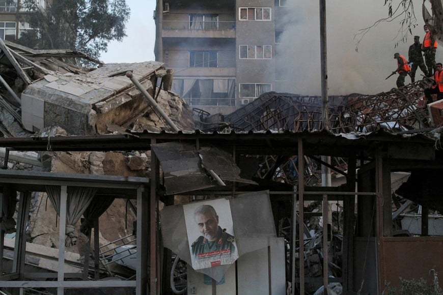 A picture of late senior Iranian military commander General Qassem Soleimani hangs amid rubble after what Syrian and Iranian media described as an Israeli air strike on Iran's consulate in the Syrian capital Damascus April 1, 2024. REUTERS/Firas Makdesi 
     TPX IMAGES OF THE DAY