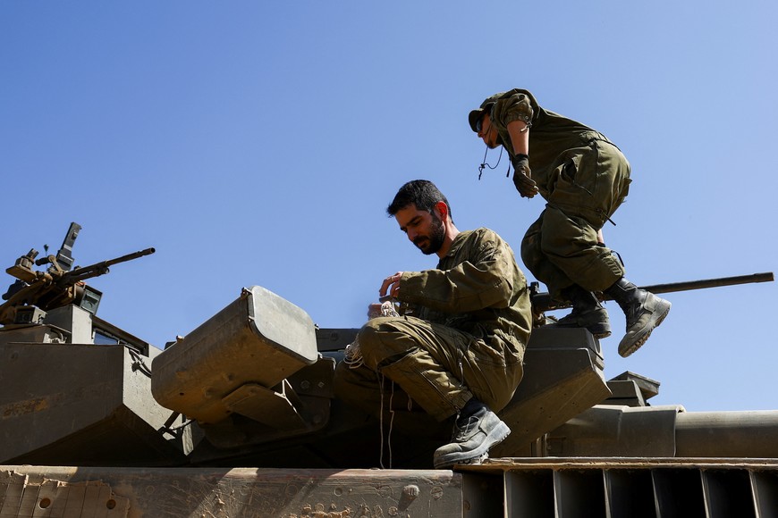 Israeli soldiers conduct some maintenance work on a Merkava tank near the Israel-Gaza border, amid the ongoing conflict between Israel and the Palestinian Islamist group Hamas, on the Israeli side April 3, 2024. REUTERS/Hannah McKay