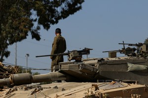 An Israeli soldier stands next to a Merkava tank near the Israel-Gaza border, amid the ongoing conflict between Israel and the Palestinian Islamist group Hamas, on the Israeli side April 3, 2024. REUTERS/Hannah McKay