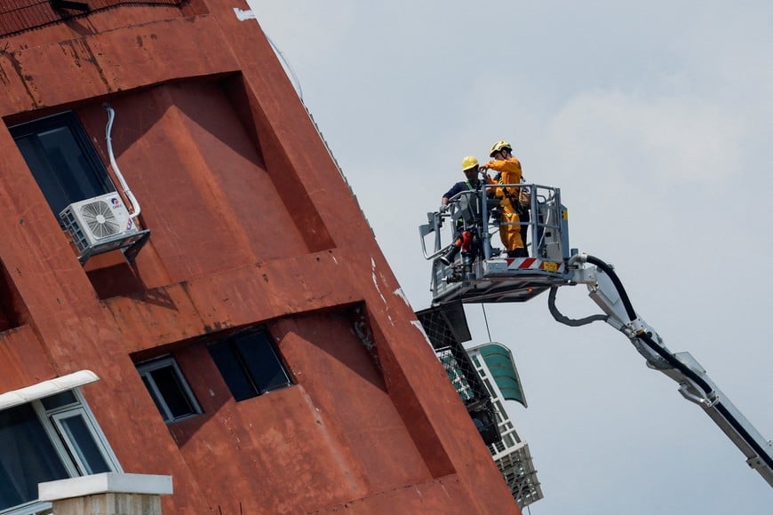 Workers carry out operations while on the elevated platform of a firefighting truck at the site where a building collapsed, following the earthquake, in Hualien, Taiwan April 4, 2024. REUTERS/Carlos Garcia Rawlins
     TPX IMAGES OF THE DAY