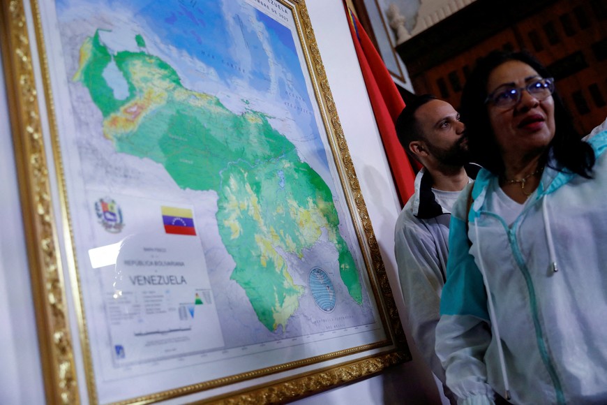 FILE PHOTO: People stand during an event to unveil a map of Venezuela showing the disputed Esequibo region as part of the country, as tensions between Venezuela and Guyana have ratcheted up in recent weeks over a long-running territorial dispute, in Caracas, Venezuela, December 8, 2023. REUTERS/Leonardo Fernandez Viloria/File Photo