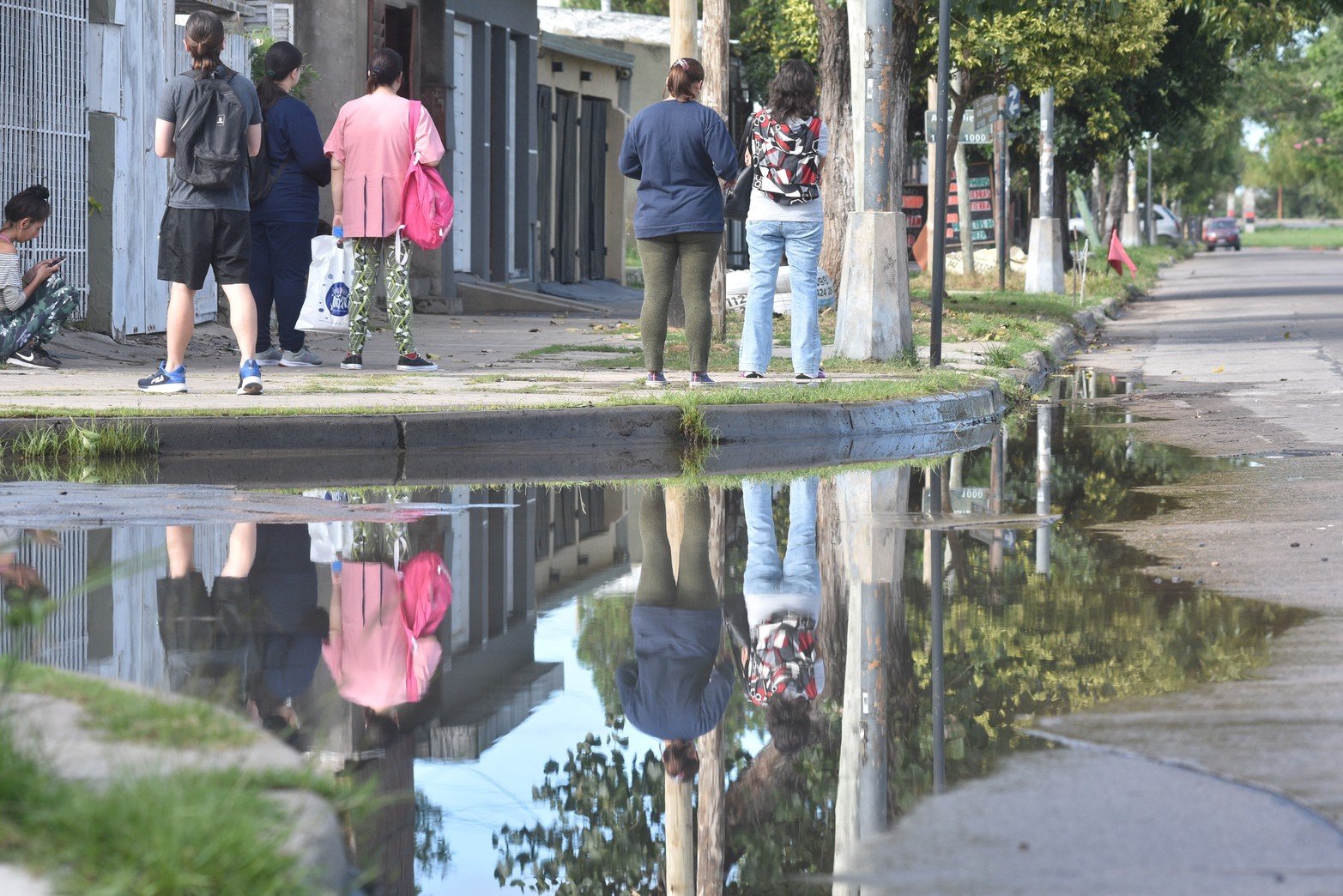 Vecinos esperando el colectivo. El olor nauseabundo es muy fuerte. 