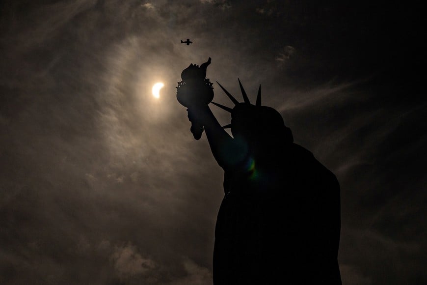 The Statue of Liberty is seen during a partial solar eclipse, where the moon partially blots out the sun, at Liberty Island in New York City, U.S., April 8, 2024. REUTERS/David Dee Delgado