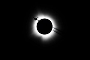 An airplane passes near the total solar eclipse during the Hoosier Cosmic Celebration at Memorial Stadium in Bloomington, Indiana, U.S. April 8, 2024. Bobby Goddin/USA Today Network via REUTERS
NO RESALES. NO ARCHIVES. MANDATORY CREDIT