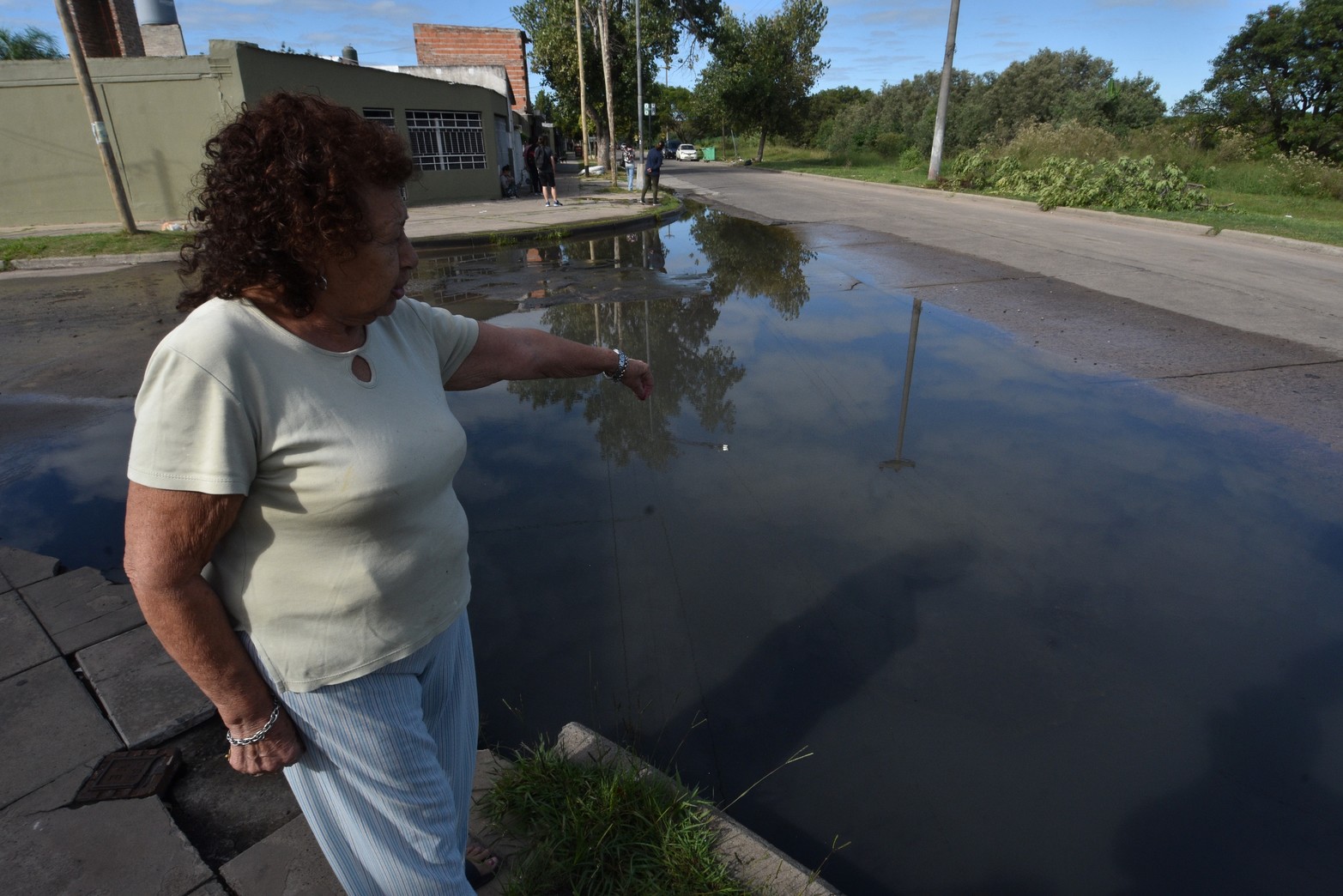 Una vecina señala donde hay una boca de tormenta. Por allí sale el agua servida.