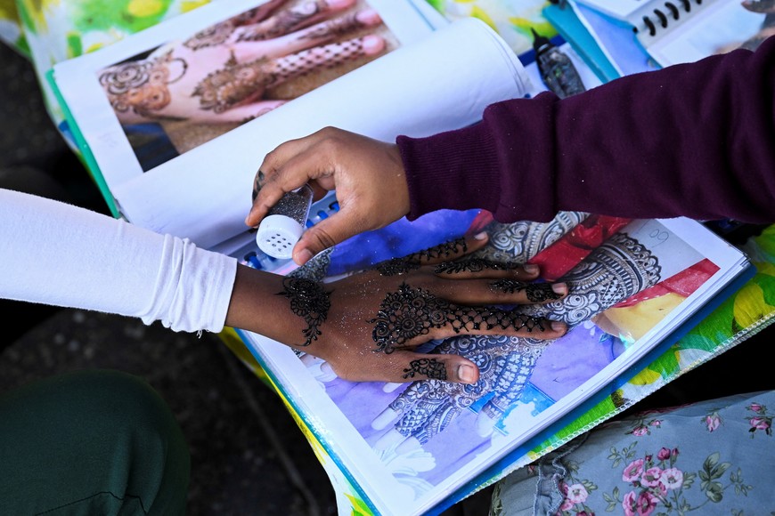 A Muslim woman paints with henna during Eid al-Fitr, marking the end of the holy month of Ramadan in the suburb of Lakemba in Sydney, Australia, April 9, 2024. REUTERS/Jaimi Joy