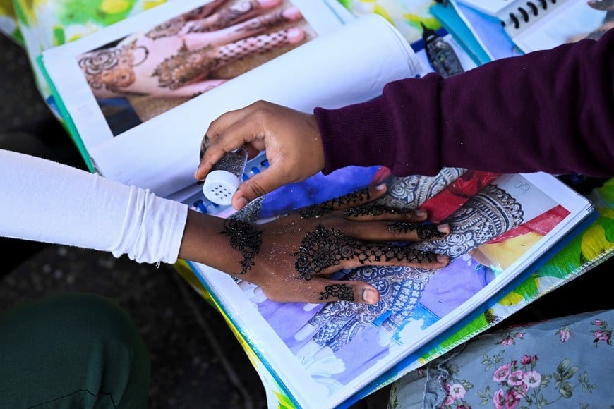 A Muslim woman paints with henna during Eid al-Fitr, marking the end of the holy month of Ramadan in the suburb of Lakemba in Sydney, Australia, April 9, 2024. REUTERS/Jaimi Joy