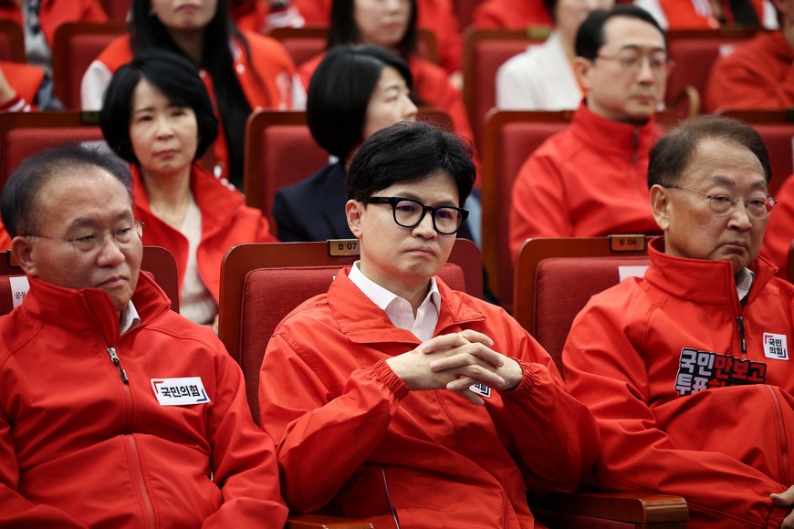 The South Korean ruling People Power Party's leader Han Dong-hoon and party members watch a news report on the results of exit polls for the 22nd parliamentary election at the National Assembly in Seoul, South Korea, April 10, 2024.   REUTERS/Kim Hong-Ji/Pool