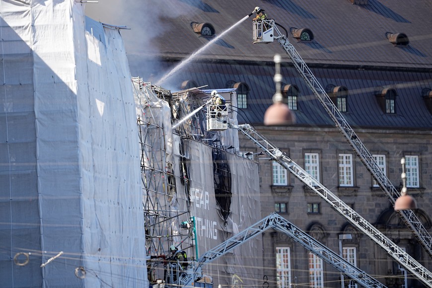 Firefighters work after a fire broke out at the Old Stock Exchange, Boersen, in Copenhagen, Denmark April 16, 2024.  Ritzau Scanpix/Mads Claus Rasmussen via REUTERS    ATTENTION EDITORS - THIS IMAGE WAS PROVIDED BY A THIRD PARTY. DENMARK OUT. NO COMMERCIAL OR EDITORIAL SALES IN DENMARK.