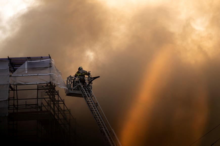 A firefighter works after a fire broke out at the Old Stock Exchange, Boersen, in Copenhagen, Denmark April 16, 2024.  Ritzau Scanpix/Ida Marie Odgaard via REUTERS    ATTENTION EDITORS - THIS IMAGE WAS PROVIDED BY A THIRD PARTY. DENMARK OUT. NO COMMERCIAL OR EDITORIAL SALES IN DENMARK.
