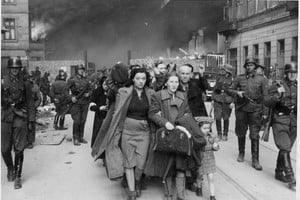 Tristemente célebre. Una de las imágenes más conocidas del Informe Stroop, documento oficial preparado por el general Jürgen Stroop para el jefe de las SS, Heinrich Himmler, muestra a un grupo de soldados nazis apremiando a una familia judía para que abandone el gueto de Varsovia (en llamas, al fondo de la escena).