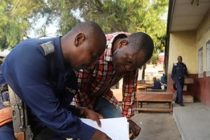 Un policía congoleño y un trabajador de la Comisión Electoral Nacional Independiente del Congo (CENI) preparan una mesa electoral en Kinshasa, República Democrática del Congo. Reuters