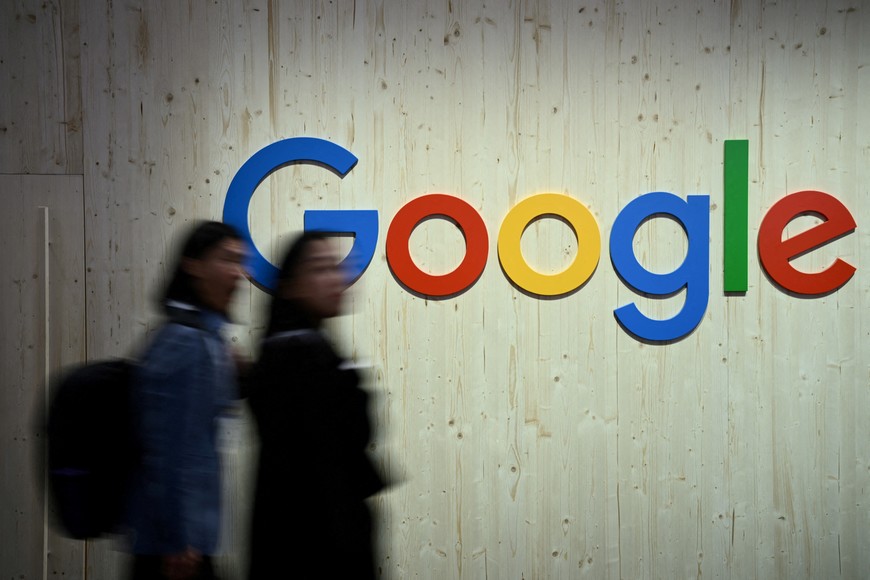 FILE PHOTO: People walk next to a Google logo during a trade fair in Hannover Messe, in Hanover, Germany, April 22, 2024.  REUTERS/Annegret Hilse/File Photo