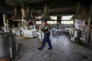 Personal de limpieza despeja una zona de cocina en un hospital afectado por un bombardeo aéreo ruso. Crédito: REUTERS.