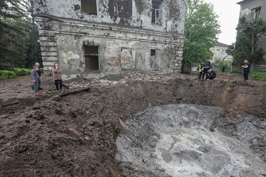 Police experts work near a crater at the site of hospital buildings damaged by a Russian missile strike as people watch, amid Russia's attack on Ukraine, in Kharkiv, Ukraine April 27, 2024. REUTERS/Vyacheslav Madiyevskyy