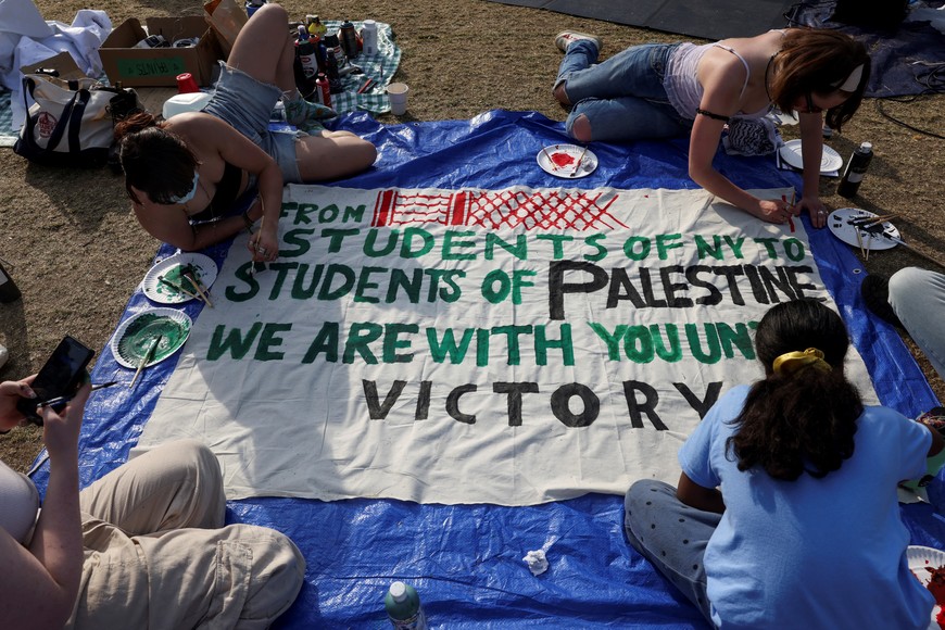 Students at Columbia University paint a response to a message written by Palestinians in Rafah thanking students for their support as they continue to maintain a protest encampment on campus in support of Palestinians, during the ongoing conflict between Israel and the Palestinian Islamist group Hamas, in New York City, U.S., April 28, 2024. REUTERS/Caitlin Ochs