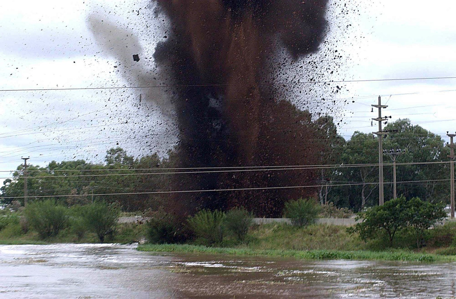 La explosión de las defensas. Con el río Salado muy alto, del otro lado de la defensa el agua superaba al río . Se decidió reventar en tres lugares. En la foto, terraplén Irigoyen, cerca del puente carretero. 