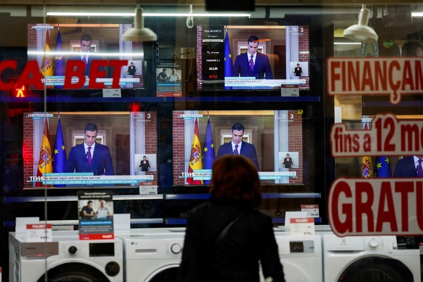 A person watches a TV broadcasting the statement by Spain's Prime Minister Pedro Sanchez, in El Masnou, north of Barcelona, Spain April 29, 2024. REUTERS/Albert Gea