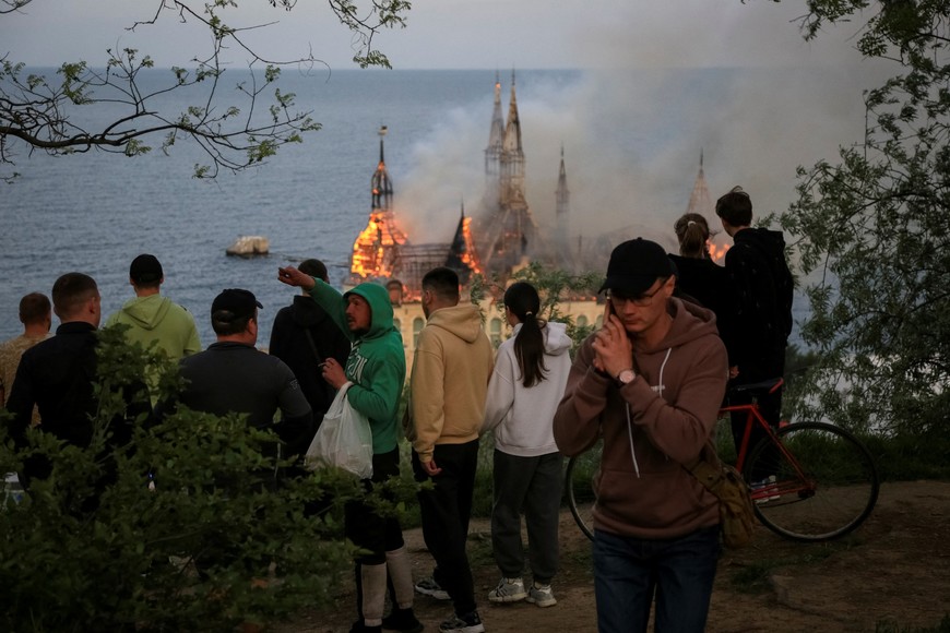 People look at a burning educational institution building after a Russian missile strike, amid Russia's attack on Ukraine, in Odesa, Ukraine April 29, 2024. REUTERS/Sergey Smolentsev