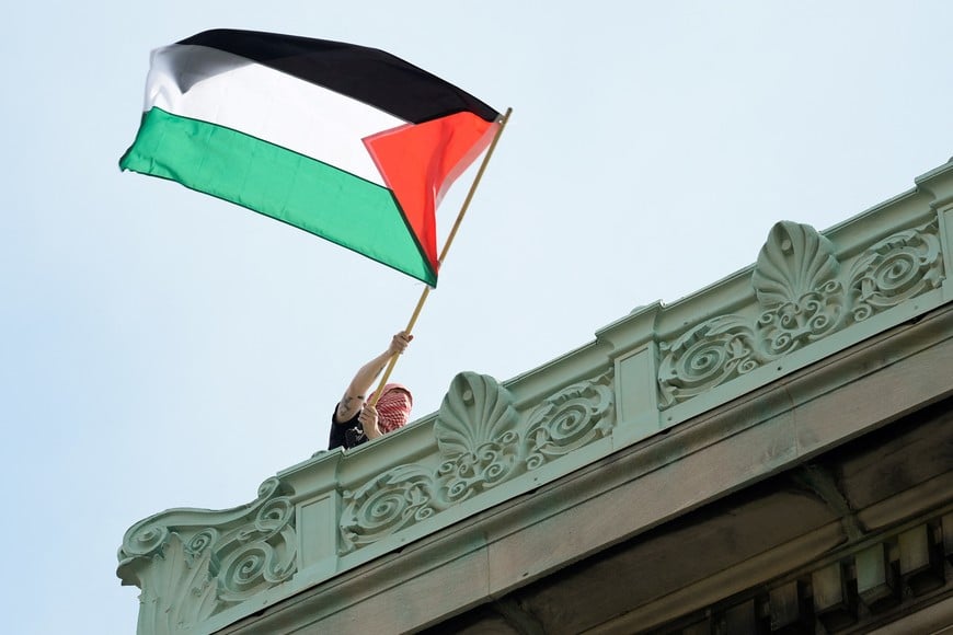 A student protester waves a Palestinian flag above Hamilton Hall on the campus of Columbia University, in New York, U.S., April 30, 2024. Mary Altaffer/Pool via REUTERS