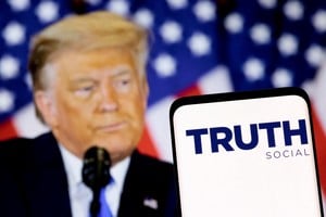 FILE PHOTO: The Truth social network logo is seen on a smartphone in front of a display of former U.S. President Donald Trump in this picture illustration taken February 21, 2022. REUTERS/Dado Ruvic/Illustration/File Photo