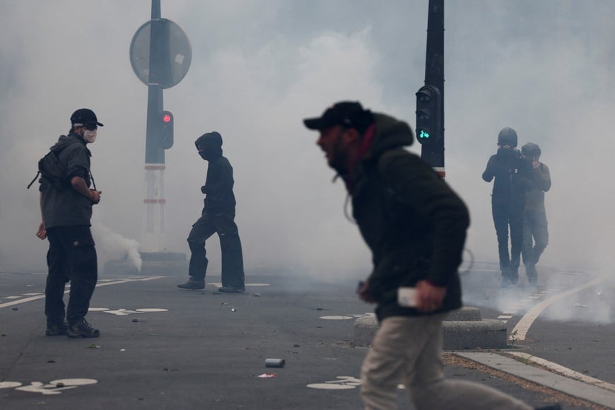 Protesters walk amid tear gas during the traditional May Day labour union march in Paris, France, May 1, 2024. REUTERS/Stephanie Lecocq