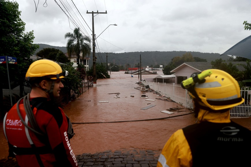 Rescue workers stand near a flooded area next to the Taquari River during heavy rains in Encantado, Rio Grande do Sul state, Brazil, May 2, 2024. REUTERS/Diego Vara