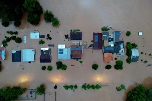 A drone view shows houses in the flooded area next to the Taquari River during heavy rains in the city of Encantado in Rio Grande do Sul, Brazil, May 1, 2024. REUTERS/Diego Vara