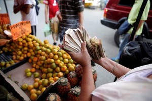 caos total por el derrumbe de la economia El calvario de los venezolanos de la montaña de billetes y al corralito de bolívares
Con una inflación de 720%

Muchos habían ahorrado miles de billetes de 100 para las compras navideñas. Pero el gobierno los obligó a depositarlos en los bancos, quedándose con nada.

A vendor counts Venezuelan bolivar notes at her stall in a street market in the slum of Petare in Caracas, Venezuela, December 12, 2016. REUTERS/Marco Bello venezuela  entre el colapso economico y la vida en la desgracia crisis politica y economica en el pais gente comprando en negocios comercios