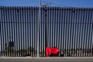 Miembros de la familia Orduño Castro usan un paño rojo para protegerse del sol mientras se se reúnen con un familiar que vive en Carolina del Norte y no puede cruzar a México, en la valla fronteriza que separa México y Estados Unidos, visto desde Mexicali, México, 6 de mayo de 2024. Reuters