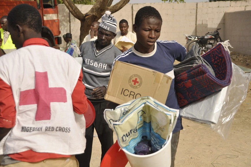 A man carries relief materials distributed by the Red Cross in Kano at a relief camp for people fleeing the Boko Haram violence, in Dawaki, a local government area in Kano, December 16, 2014.  REUTERS/Stringer (NIGERIA - Tags: CIVIL UNREST SOCIETY) nigeria kano  nigeria desplazados por la violencia religiosa de boko haram cruz roja reparte alimentos y medicamentos en campo de Dawaki