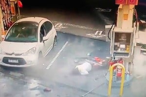 La camioneta contra el surtidor y la empleada lesionada en el piso.