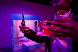 A person takes a selfie while holding a drink during the World of Barbie immersive experience preview in Santa Monica, California, U.S., April 12, 2023.  REUTERS/Mario Anzuoni