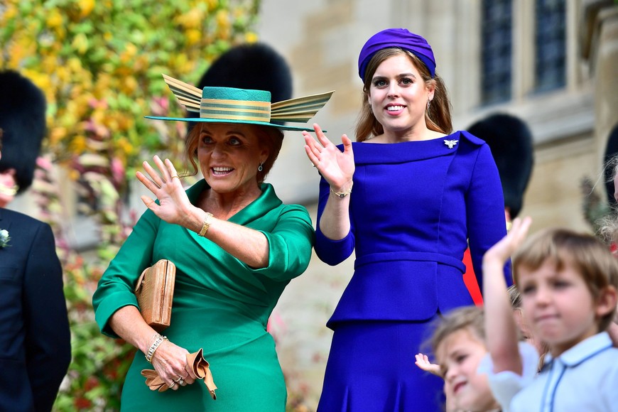 Princess Beatrice and her mother Sarah Ferguson wave to Princess Eugenie and her new husband Jack Brooksbank as they leave St George's Chapel in Windsor Castle, Windsor, Britain, October 12, 2018. Victoria Jones/Pool via REUTERS windsor inglaterra princesa beatriz duquesa Sarah Ferguson casamiento de la princesa inglesa boda real nieta de la reina invitados