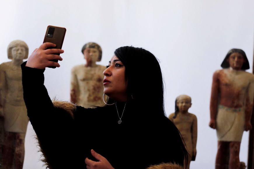 A women takes a selfie after the announcement of the discovery of 4,300-year-old sealed tombs, which have made a number of important archaeological discoveries dating to the fifth and sixth dynasties of the Old Kingdom, also stated that the expedition had found a group of Old Kingdom tombs, indicating that the site comprised a large cemetery, where the most important tomb belonged to Khnumdjedef, an inspector of the officials, a supervisor of the nobles, and a priest in the pyramid complex of Unas, the last kind of the fifth dynasty, in Egypt's Saqqara necropolis, in Giza, Egypt, January 26, 2023. REUTERS/Mohamed Abd El Ghany