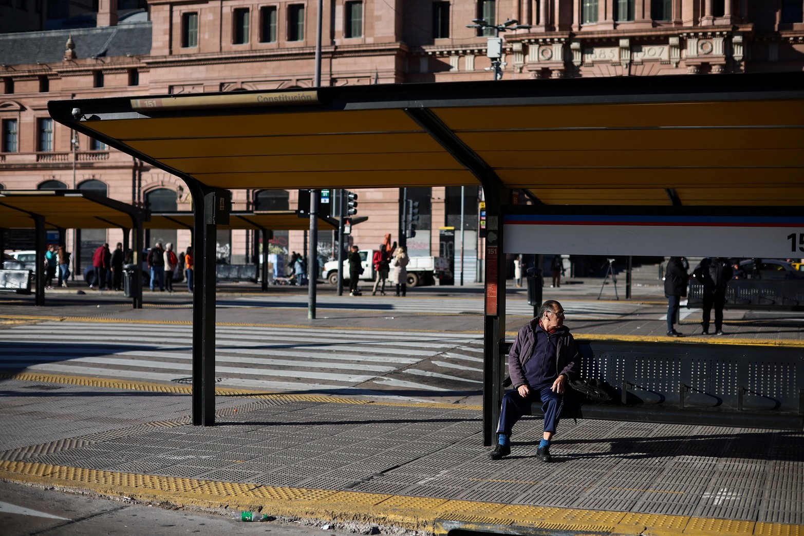Los viajeros esperan un autobús fuera de la estación de tren Plaza Constitución, durante una huelga general de 24 horas contra la política de ajuste del gobierno del presidente argentino Javier Milei.