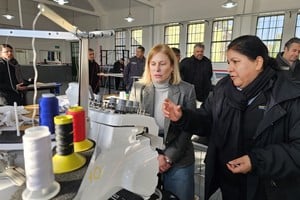 La vicegobernadora con una empleada que le enseña una de las tantas máquinas que tiene IAPIP en su sede en Coronda.