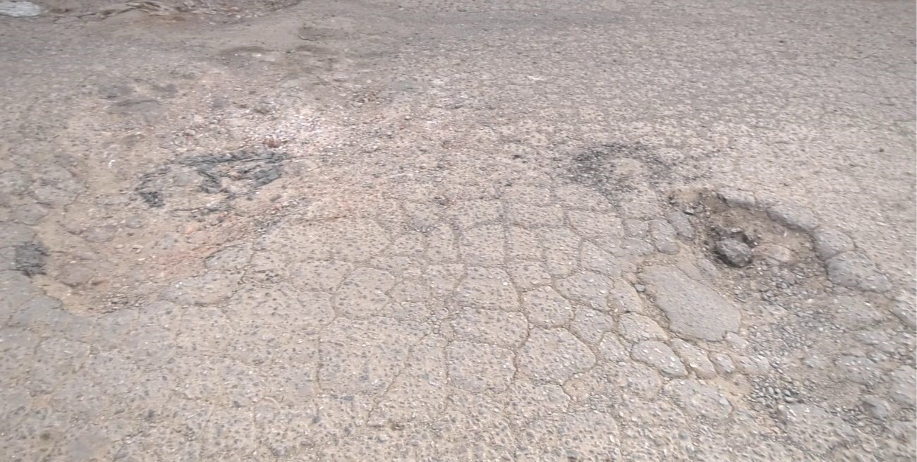 Los baches del asfalto de calle Azcuénaga.