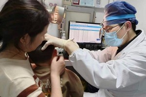 El Dr. Yilai Shu examina a un niño.