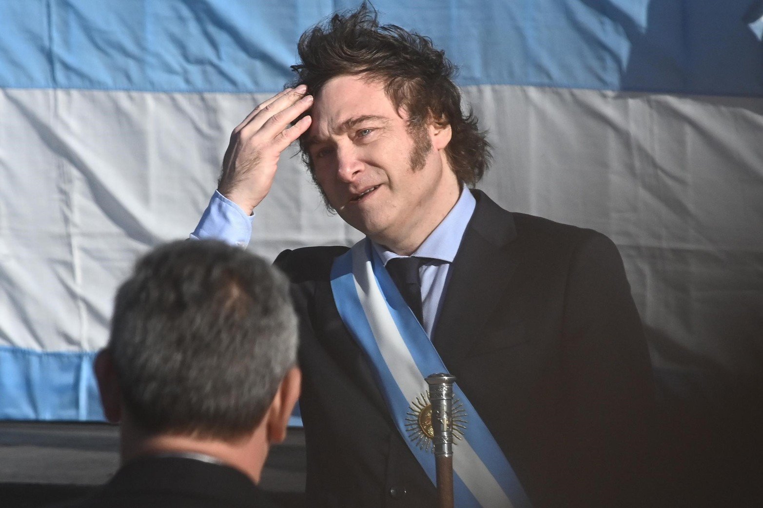 El flequillo flameaba. Durante el acto hubo ráfagas de viento y el Presidente Javier Milei recurrió a acomodarlo.