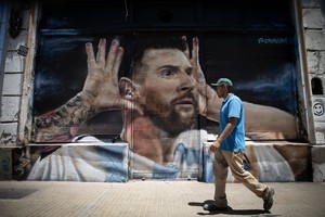Un hombre camina frente a un mural de Messi realizado sobre la cortina metálica de un local de calle Bolívar al 900, en el barrio de San Telmo, el 30 de diciembre de 2022. Foto: Agencia Xinhua