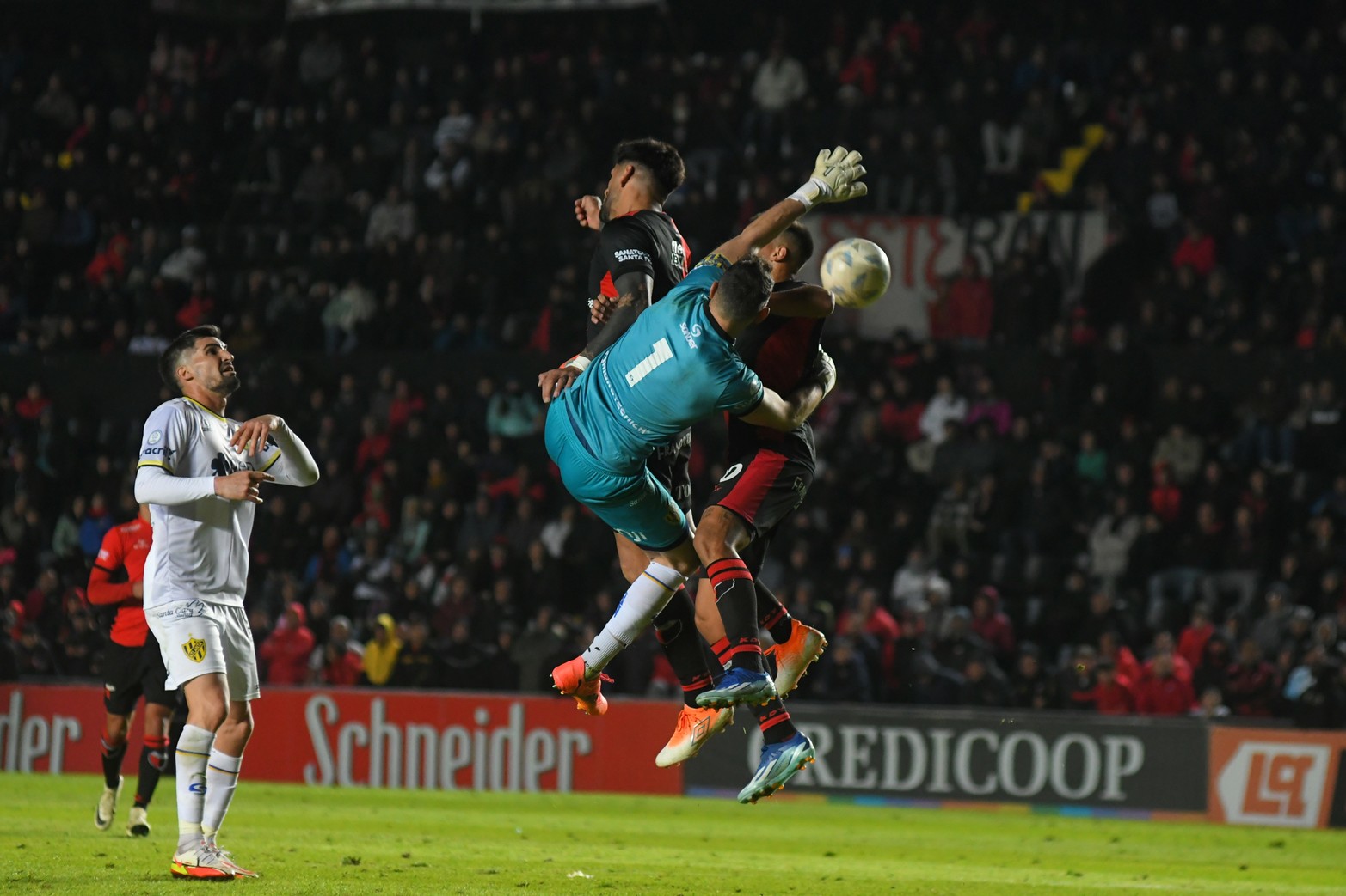 Dos contra uno. El arquero Alejandro Sánchez en el aire junto a Javier Toledo y Nicolás Leguizamón. 