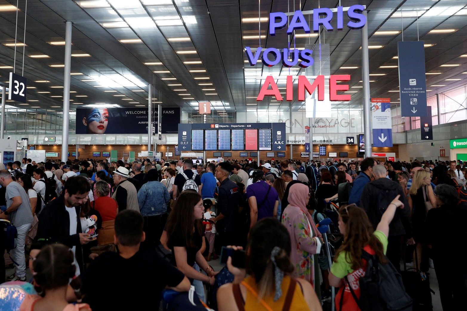 Los pasajeros esperan dentro de la Terminal 3, ya que las operaciones se vieron interrumpidas debido a un problema global de TI, en el aeropuerto de Orly, cerca de París, Francia.
